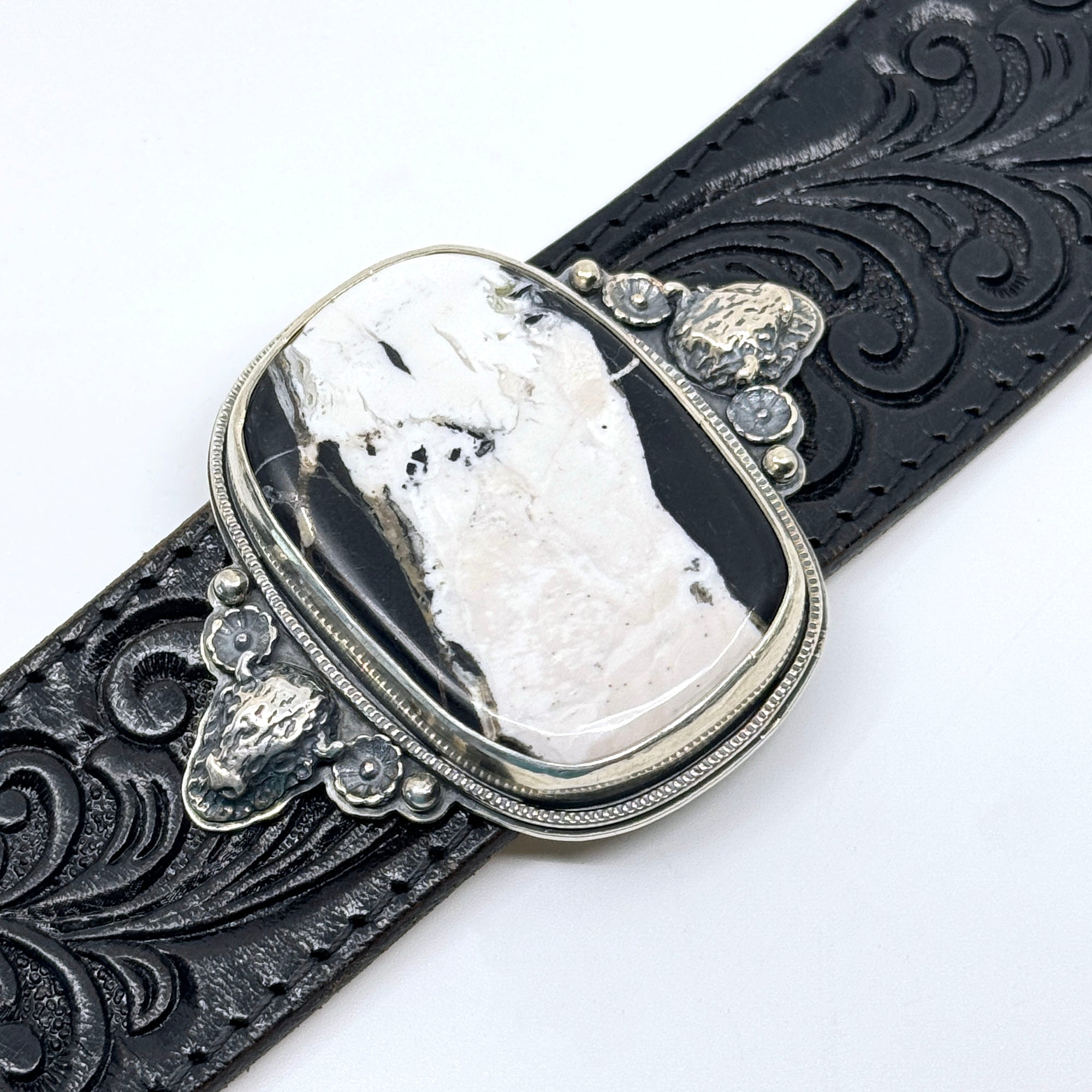Detail of Leather cuff bracelet with White Buffalo stone on black western leather belt
