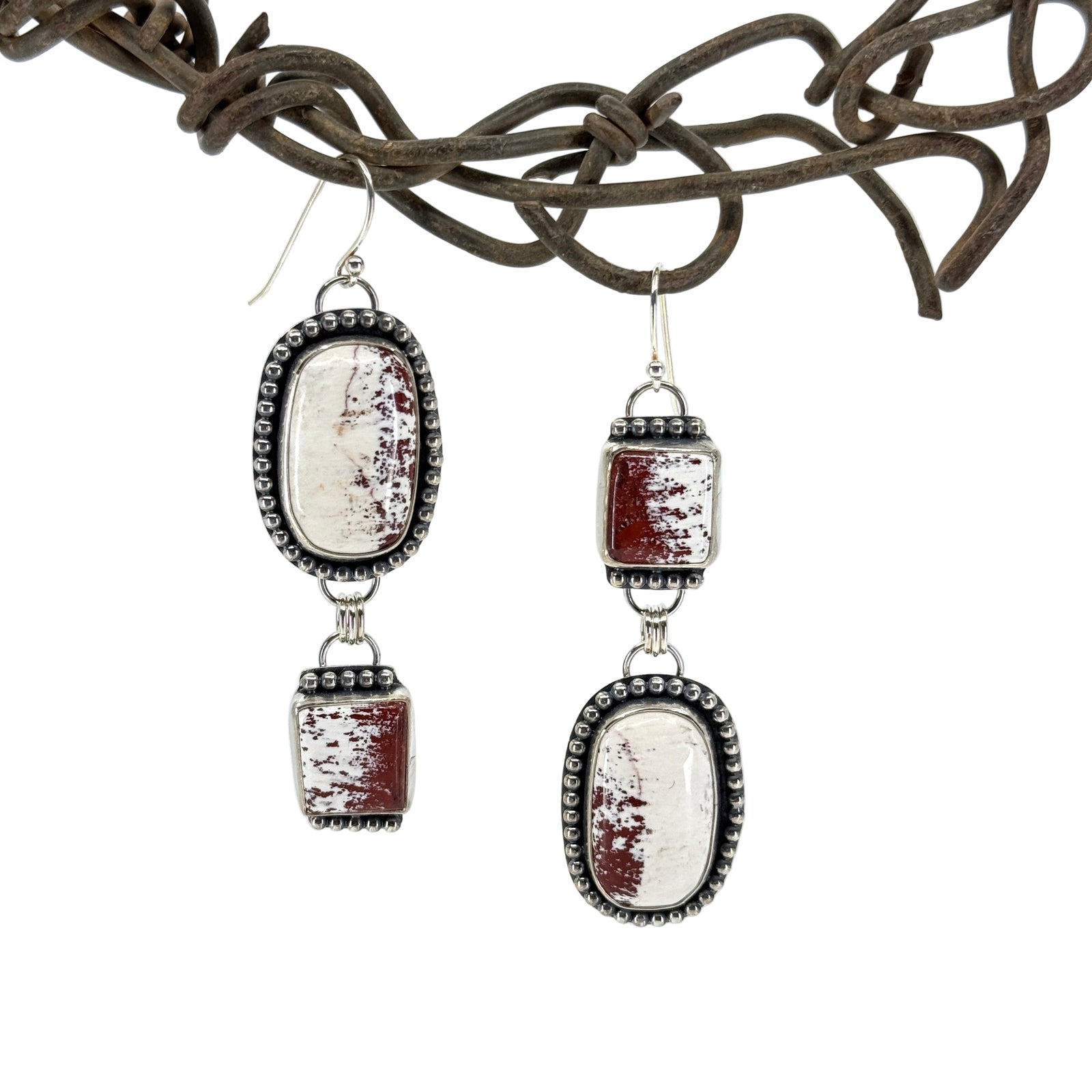 Sterling silver asymmetrical earrings with rare red buffalo stones, handcrafted in Arizona by Thunderheart Jewelry.