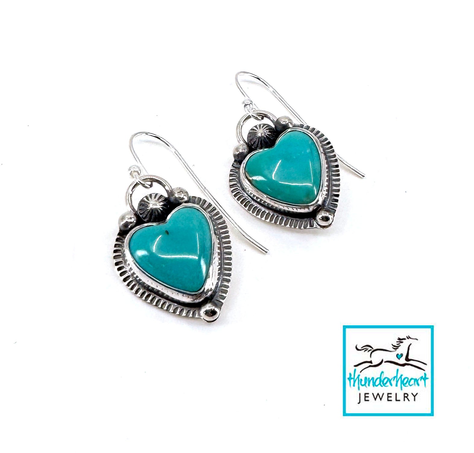 Turquoise heart-shaped earrings with silver frames on a white background, featuring Thunderheart Jewelry logo.