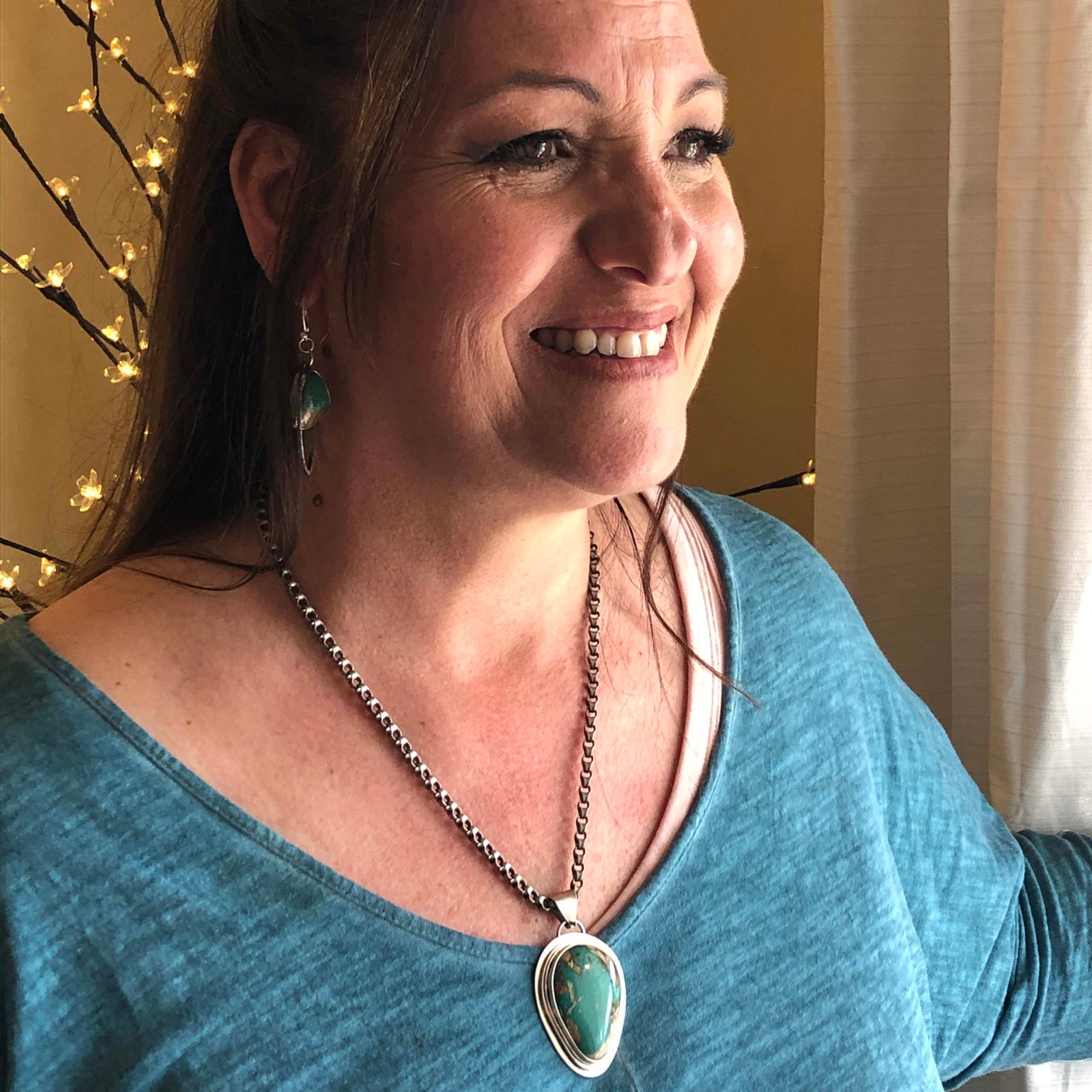 Happy customer wearing custom pendant and earrings by Thunderheart Jewelry